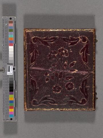 John B. Colton seated with gun on table at his elbow