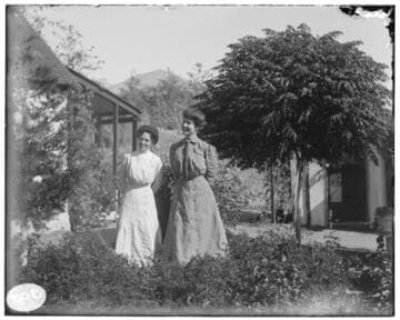 Two women standing outside of an residence