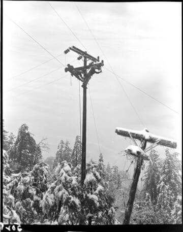 Linemen working at top of pole in snow