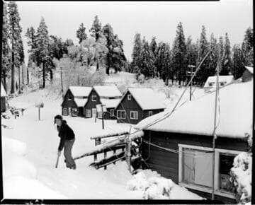 Shoveling snow by cabins