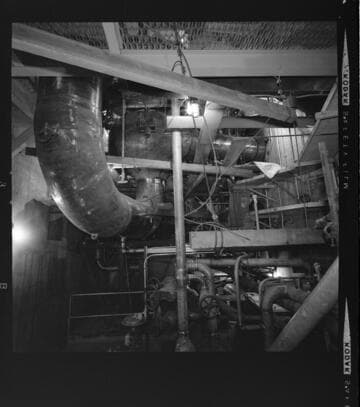 Men working construction on pressure pipes at steam power plant