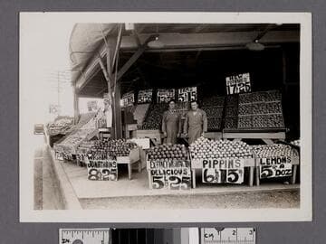Two men standing at an outdoor produce market, Los Angeles, California