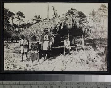 Seminole Indians in front of brush hut