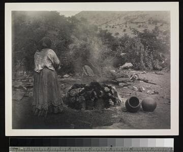 Papago Indian woman using oven for pottery.  Near Bisbee, Arizona