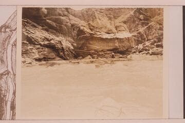 Boat with two men in it in some fast water.  It is probably Sheer Wall Rapid with a double exposure at Boulder Narrows