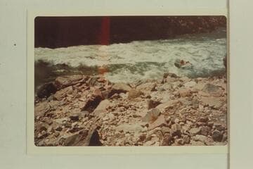 Swanson in an outboard powered Zodiac craft climbing onto the tongue of 232 Mile Rapid at Mile 232.4 better known as Requiem Rapid