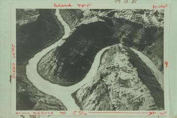 The confluence of the Green and Colorado Rivers. The Green River enters from right.  The Colorado (formerly the Grand) flows up into the picture from lower left and the combined river moves into the Cataract Canyon at upper left
