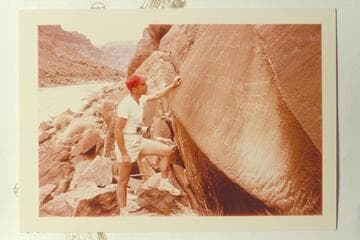 Jorgen Visbak reads the Best expedition and the Wright inscriptions at Mile 204 1/2, Cataract Canyon.  Note the edge of 203 Mile rock over Jorgen's head