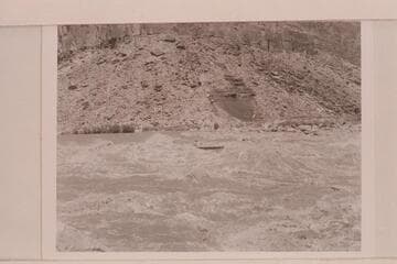 Jimmy Jordan pilots the "June Bug" through Badger Creek Rapid.  Ivins McDonald is passenger
