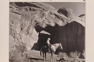 Nancy Daly sits her horse in front of the natural bridge in a side canyon of Navajo Canyon, Arizona
