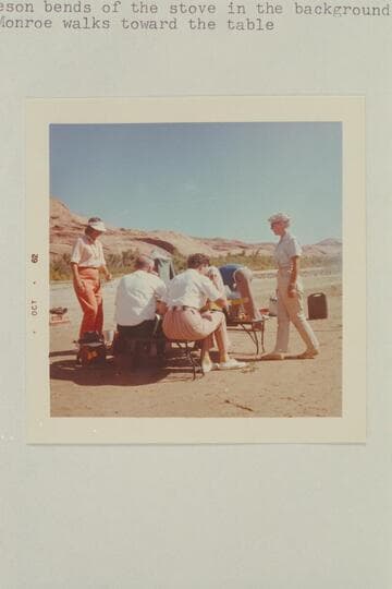 The wedding breakfast of Harry and Dorothy Aleson.  Dorothy Aleson at left.  Bishop Wells and Nina Robison have their back to the camera, Harry Aleson bend over stove in background and Barbara Monroe walks toward table