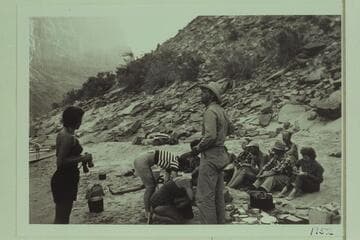 Breakfast above mouth of Prospect Canyon at head of Vulcan Rapid.  The Mexican Hat Expedition party; Frank Wright stands in the foreground