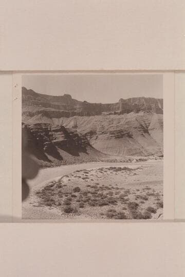 Unkar Rapid at [as]  approximately 60,000 cfs. water runs through boulders on beach