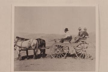 Below the Wheeler Ranch near the Green River.  Arthur P. Ballard in black hat, Brandes and McReynolds in back seat