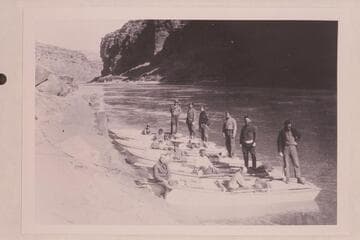 Pathe-Bray party below Lees Ferry.  Eddy sits on the bow of the near boat.  Boatmen from left to right are Daily, Woodbury, Rodin, Clark, Samoff, Dodge.  Barber stands second from left; Kershnerr is second from right; LaRue is at right