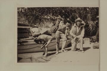 Guy Forcier and Joe Desloge before the start of the motor transit of Grand Canyon.  Willie Taylor wets his head at left.  The "Esmeralda II" is at the beach