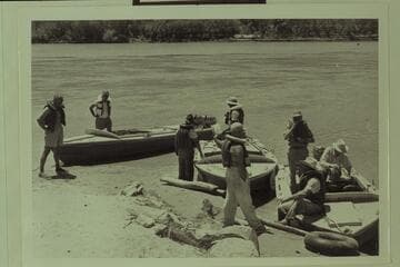 Just before departure from Lees Ferry for Grand Canyon traverse.  Masland stands left.  Eisaman stands in the "Bootoo."  Taylor holds the line of the "Cactus."  Visbak stands in the "Cactus."  Marston with hands in pockets on beach