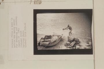 Belknap fills a boat to settle the muddy water for drinking and cooking