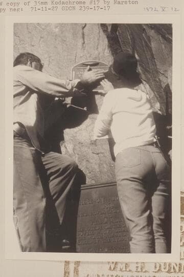 Ranger Jim Bailey and Frankie Frzier Strathairn fastening the 1934 plaque back in the wall at Separation Canyon