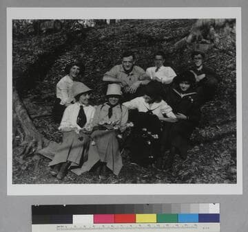 Edwin Powell Hubble and seven unidentified companions, seated outdoors near trees