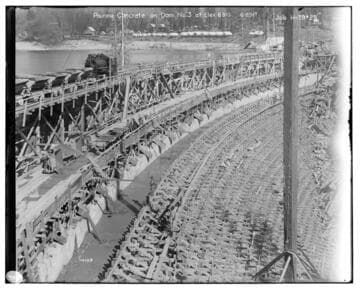 Big Creek Huntington Lake Dams - Pouring concrete on Dam #3 at elevation 6910. [Locomotive pushing concrete batch cars onto dam] Job H