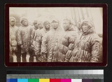 Group of Alaska native men on unidentified ship with rain gear