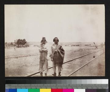 Two Southwest Indian men standing on railroad tracks