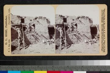 Adults and children outside a pueblo home