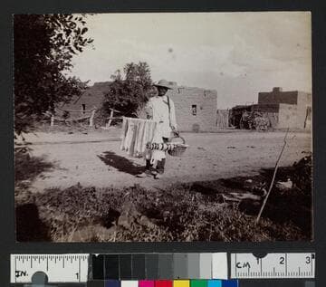 A vendor selling ribbon in an unidentified pueblo or settlement