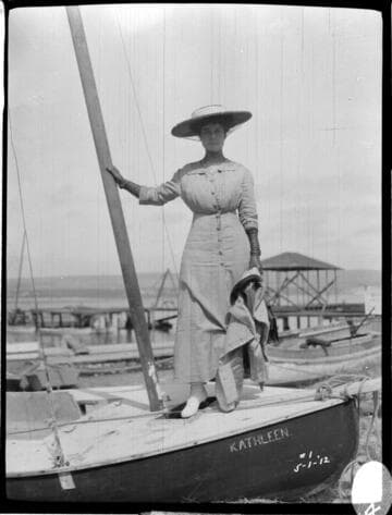 A woman standing on a boat named "Kathleen"
