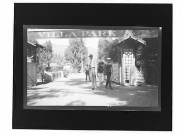 People walking under "Villa Park" sign