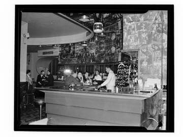 Interior of an unidentified bar, with bartender and customers