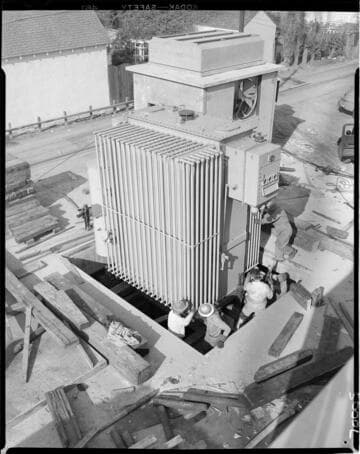 Lowering large piece of electrical equipment into underground vault