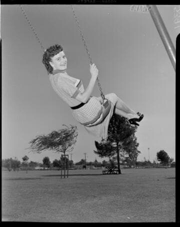 Young lady swinging in swing at park playground