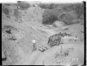 Two men and two horses excavating a ditch for the Tule Plant