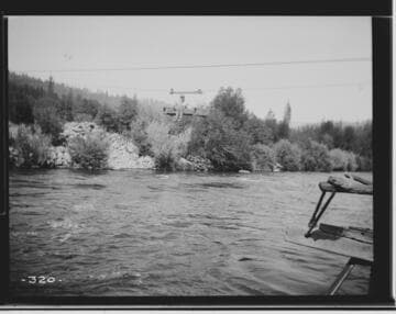 A man riding the gauging equipment on the Pitt River for the Mount Shasta Power Company