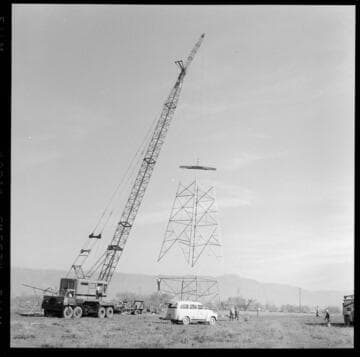 Transmission tower construction using a crane