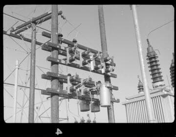 Small distribution substation near transmission tower in desert