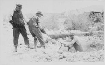 Series of 3 shots copied from a photo album page of men digging in rocky desert soil to place a power pole
