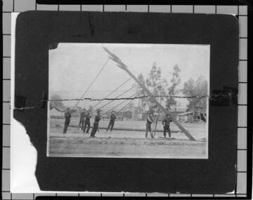 Crew of 7 men erecting distribution pole by hand