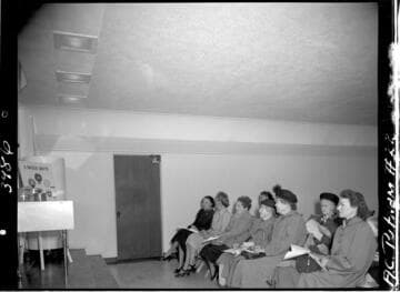 People in audience at cooking demonstration in model kitchen