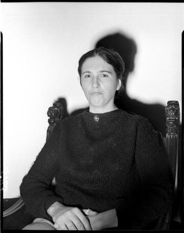 Lady seated in chair against white backdrop