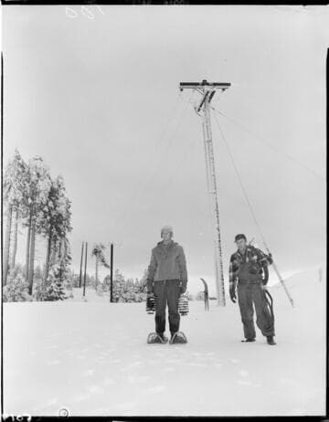 Two men with snow shoes in front of Sno