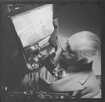 Capt. R.B. Haselden looking at a manuscript