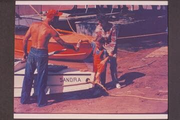 Sandra Nevills christening the "Sandra"; Lees Ferry prior to start of Grand Canyon traverse