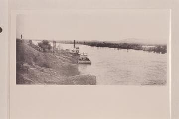 The steamer "Cochan" and the barge "Silas J. Lewis" moored to the river bank at the Yuma custom house