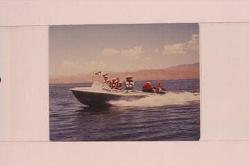 Buzz Belknap piloting the "Cactus" on Lake Mead.  Buzz Belknap at the wheel, Jeff Marston, Jim Jordan, Elsie I'Anson and Ed I'Anson